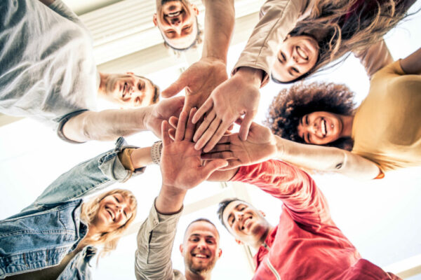 Young happy people stacking hands together outcoor - Community o